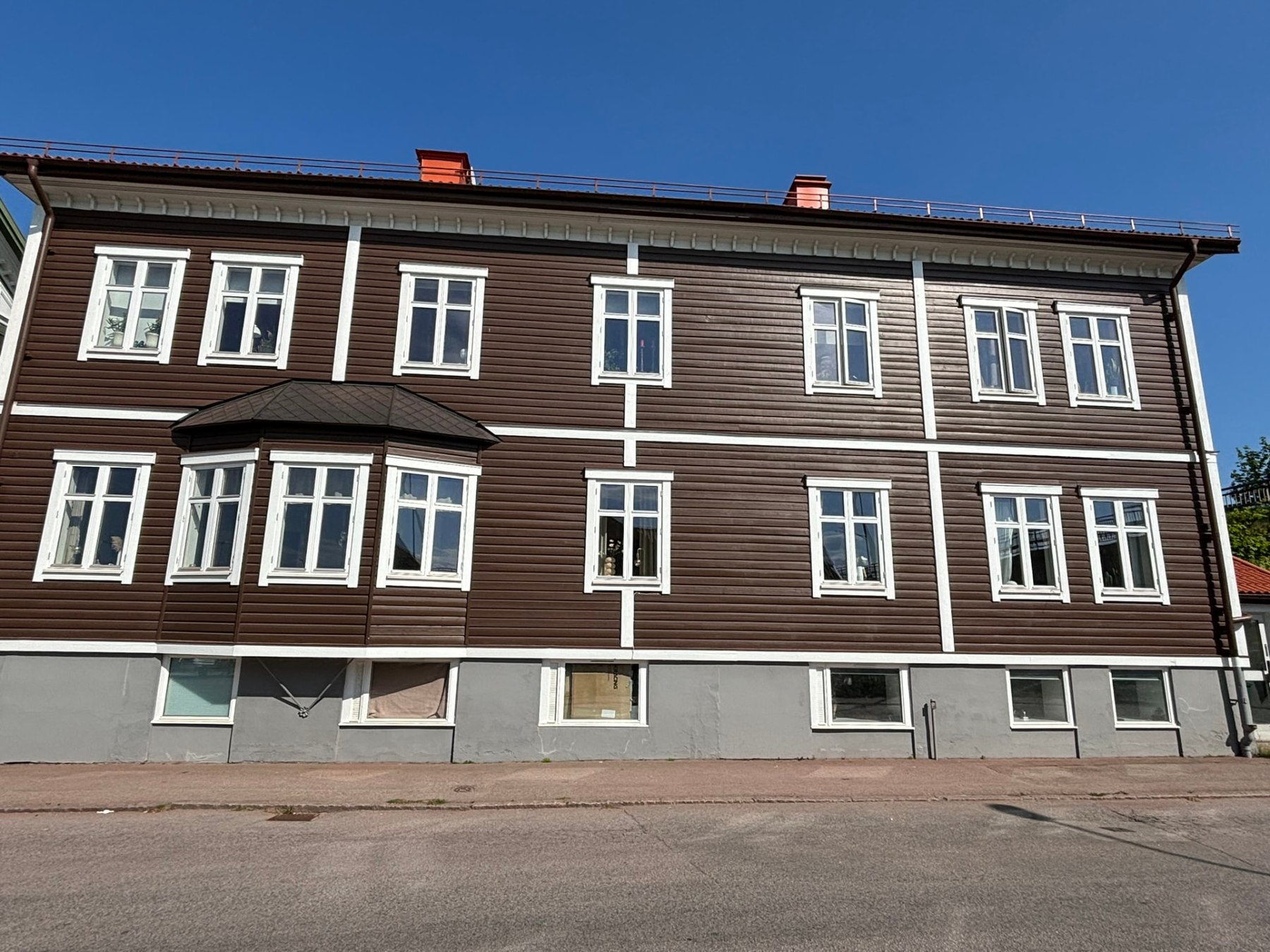 Knutsgatan 9 i Älmhult, brun träfasad med vita detaljer och rött tegeltak