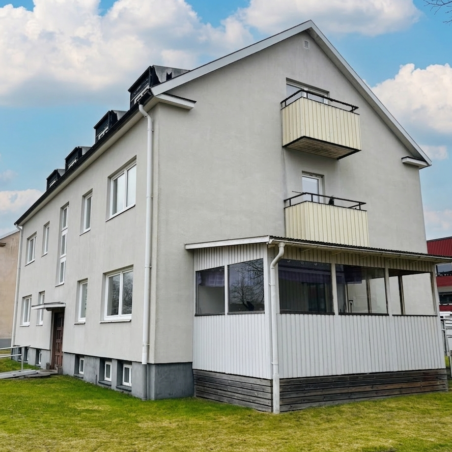 Fogdegatan 22 i Ljungby, ljus putsad fasad med balkonger och inglasad veranda